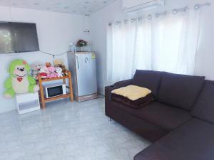 a living room with a couch and a refrigerator at Ozone farm resort in Ban Nong Talumphuk