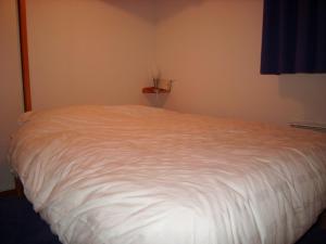 a bedroom with a white bed in a room at Appartement 3 pièces, 4 pers, skis aux pieds, balcon, parking, proche village - FR-1-733-106 in Crest-Voland