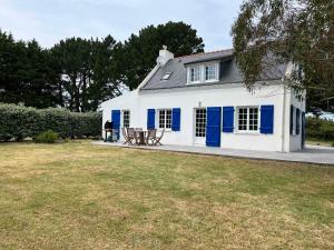 een wit huis met blauwe deuren en een tuin bij Maison Locmaria, 3 pièces, 6 personnes - FR-1-418-231 in Locmaria