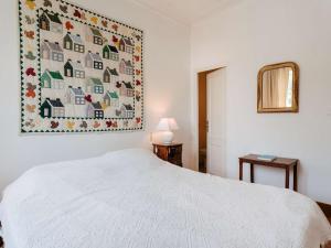 - une chambre avec un lit blanc et une couette murale dans l'établissement Appartement La Trinité-sur-Mer, 4 pièces, 6 personnes - FR-1-477-232, à La Trinité-sur-Mer
