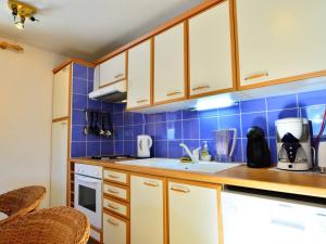 een keuken met blauwe betegelde muren en houten kasten bij Appartement La Plagne Montchavin Les Coches, 2 pièces, 5 personnes - FR-1-181-2711 in La Plagne Tarentaise