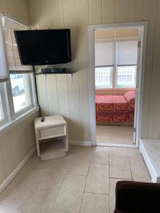 a room with a bed and a flat screen tv at Shore Beach Houses - 38 A Lincoln Avenue in Seaside Heights