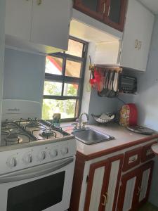 a kitchen with a stove and a sink at Anne's Homestay in Banse