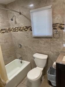 a bathroom with a toilet and a tub and a sink at Shore Beach Houses - 38 A Lincoln Avenue in Seaside Heights