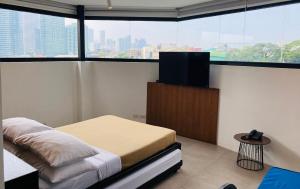 Schlafzimmer mit einem Bett und einem Flachbild-TV in der Unterkunft Gomez House in Manila