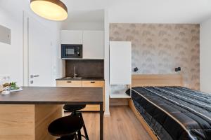 een slaapkamer met een bed en een tafel en een keuken bij Apartments Kalebić in Dugi Rat