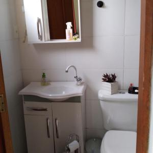 uma casa de banho com um lavatório e um WC em Sítio Sapiranga em Sapiranga