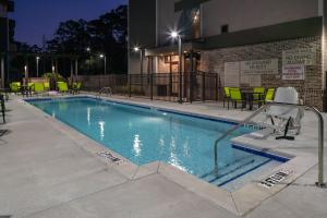 a swimming pool at night with chairs and tables at SpringHill Suites Hilton Head Island in Hilton Head Island