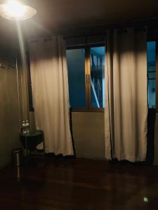 une chambre avec une porte, une table et une lumière dans l'établissement Good Space Hostel, à Khlong San