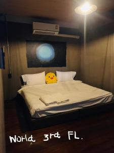 a room with a bed with a yellow pillow on it at Good Space Hostel in Khlong San