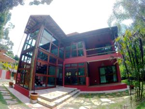 a large red building with glass windows and stairs at Ycatu Beach House in São Sebastião