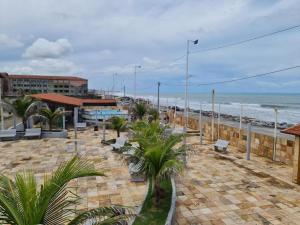 una playa con bancos y el océano en el fondo en Icaraí Atlantic Village, en Caucaia