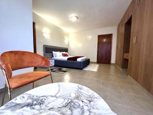 a living room with a bed and a table and chairs at Midtown Executive Suites CBD With Large Balcony in Nakuru