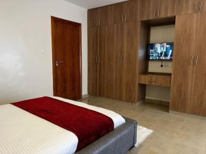 a bedroom with a bed and a flat screen tv at Midtown Executive Suites CBD With Large Balcony in Nakuru