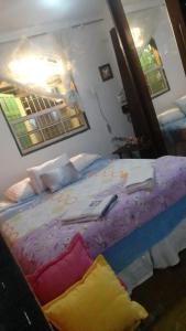 um quarto com uma cama grande e lençóis roxos em Meu cantinho em Tiradentes