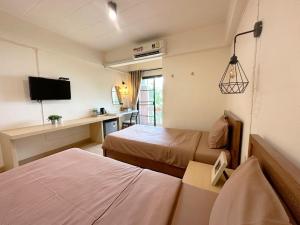 a hotel room with two beds and a desk at I-Home Residence and Hotel in Pluak Daeng