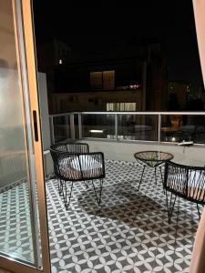 Un patio con sillas y una mesa en el balcón. en GASCON y DIAZ VELEZ en Buenos Aires