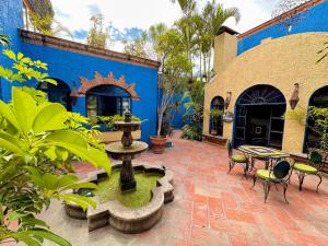 un patio con una fuente y un edificio azul en La Villa del Ensueno Boutique Hotel en Guadalajara