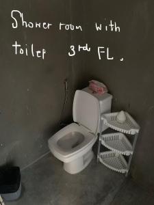 La salle de bains est pourvue de toilettes blanches. dans l'établissement Good Space Hostel, à Khlong San