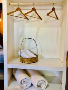Un estante con toallas y una cesta. en Pousada Salinas de Atins en Atins