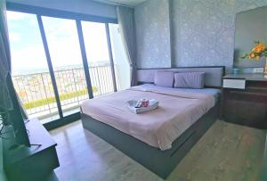 a bedroom with a bed with a tray on it at LLX Apartments at The Base condo in Pattaya Central +239 photos