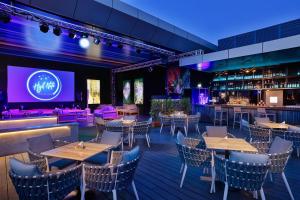 un restaurante con mesas y un bar con pantalla de proyección en Element Al Mina, Dubai Jumeirah en Dubái