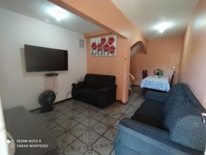 a living room with a blue couch and a tv at Casa para temporada até 9 pessoas, próximo Cabo Frio e São Pedro da Aldeia in São Pedro da Aldeia
