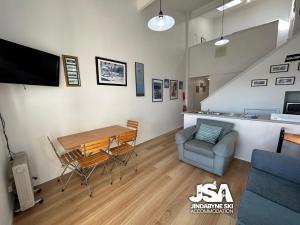 a living room with a table and a chair at Razorback 3 in Jindabyne