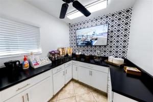 cocina con armarios blancos y encimera negra en 220 Fully Furnished, WiFi Included, en Scottsdale