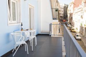 リスボンにあるALTIDO Joyful 2BR Apt with terrace nearby São Bento Palaceの市街地に面したバルコニー(テーブル、椅子付)