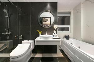ein Badezimmer mit einem Waschbecken, einem WC und einer Badewanne in der Unterkunft Shining Central Hotel & Spa in Hanoi