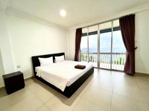 a bedroom with a large bed and a large window at JR RESORT in Ranau