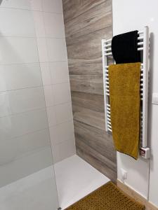 ein Bad mit einer Dusche und einem gelben Handtuch in der Unterkunft COCOON & SPA in Médis
