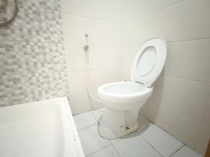 a bathroom with a toilet with the lid up at Balqies Homestay Syariah Makassar Mitra RedDoorz in Makassar