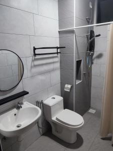 a bathroom with a toilet and a sink and a shower at MAI Desaru Utama Residence in Bandar Penawar