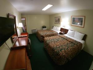 a hotel room with two beds and a flat screen tv at Budget Inn Clearfield PA in Clearfield