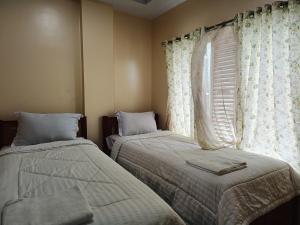 a bedroom with two beds and a window at Balqies Homestay Syariah Makassar Mitra RedDoorz in Makassar