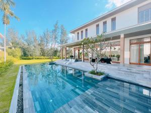 una imagen de una piscina frente a una casa en Memories Holiday beach villa Da Nang en Da Nang