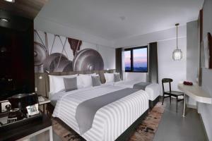 Un pat sau paturi într-o cameră la Hotel Neo Malioboro by ASTON