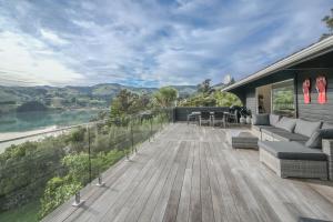 a house with a deck with a view of a river at Birdsong Bliss - Takamatua Holiday Home in Takamatua Bay +21 photos