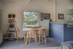 a dining room with a table and chairs and a window at Birdsong Bliss - Takamatua Holiday Home in Takamatua Bay