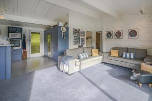 a living room with two couches and a kitchen at Birdsong Bliss - Takamatua Holiday Home in Takamatua Bay