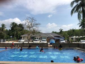 un grupo de personas en una piscina en Family Room HAMSHA VILLAGE, 