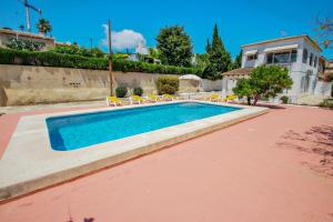 una piscina con sillas y una casa en Tere - holiday home with private swimming pool in Calpe en Calpe