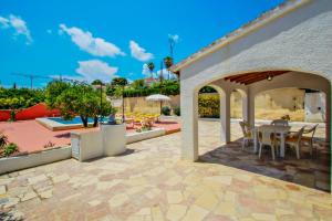 un patio con mesa y sillas bajo un pabellón en Tere - holiday home with private swimming pool in Calpe en Calpe