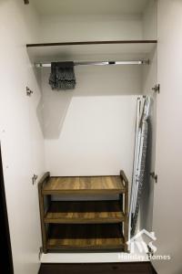 a walk in closet with wooden shelves at The Urban Oasis - Serenity in Dubai +29 photos