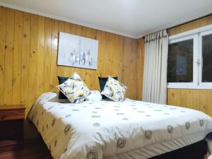 מיטה או מיטות בחדר ב-Cabañas Palmeras de Vilcún
