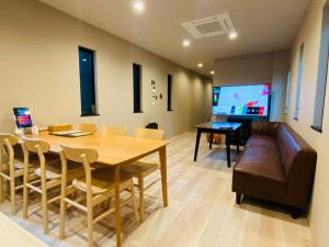 comedor con mesa, sofá y TV en SYA Hotel-上呉服町 一軒家貸し切り en Fukuoka