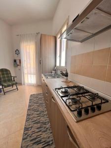 a kitchen with a stove and a sink at Birgi House Stagnone in Marsala