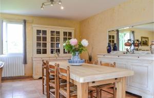 a kitchen with a table with a vase of flowers on it at Cozy Home In Saint-Georges in Bourlens